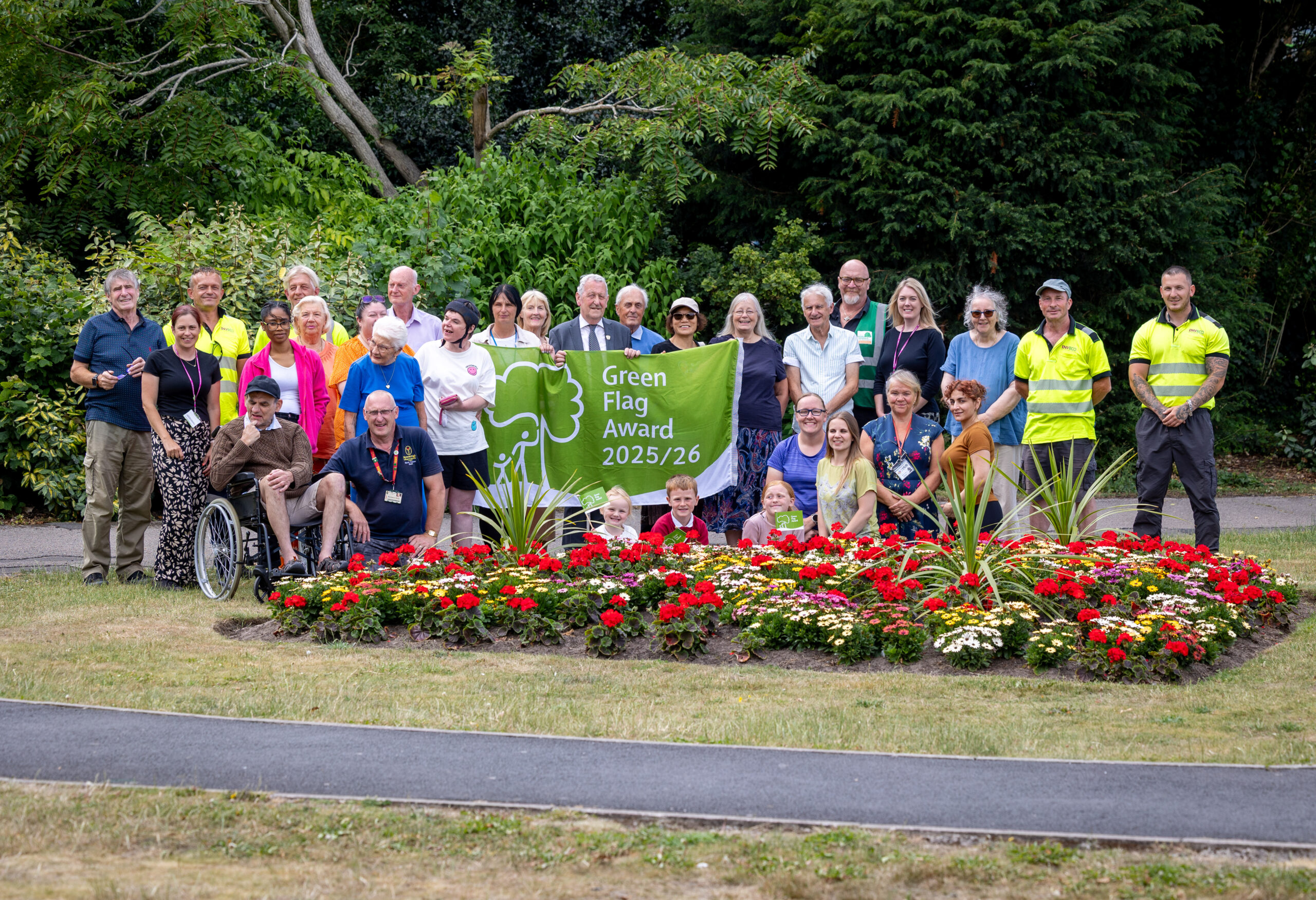 A group of people holding the green flag in a park