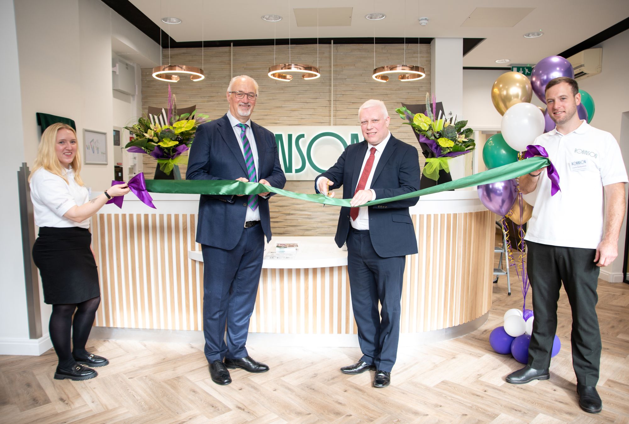 A group of people cutting ribbon
