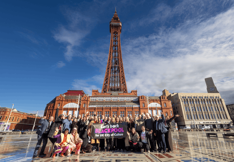A group of people standing on the comedy carpet holding a City of Culture banner
